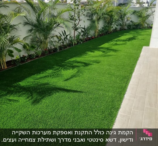 דשא ירוק, עצים ושיחים לאורך גדר לבנה